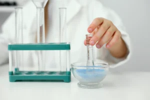 Grinding blue powder in a lab.
